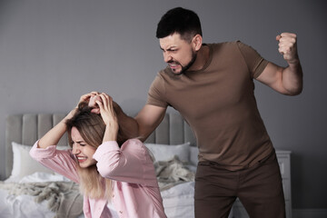 Wall Mural - Man abusing scared woman at home. Domestic violence