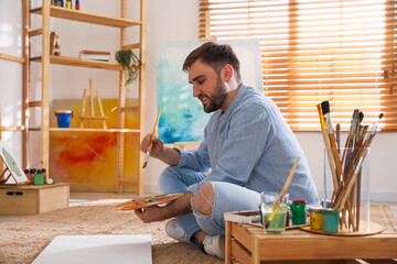 Sticker - Young man painting with brush in artist studio