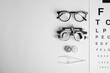 © New Africa - Different ophthalmologist tools on white background, flat lay