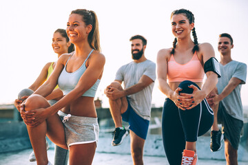 Fitness, sport, friendship and healthy lifestyle concept. Group of happy people exercising outdoor.