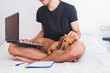 © Daniela Vazquez/Wirestock - young man with dog working
