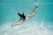 © LIGHTFIELD STUDIOS - graceful young woman in white swimsuit diving in pool