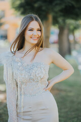 Poster - Vertical shot of a beautiful young Caucasian female posing outdoors in a formal gown