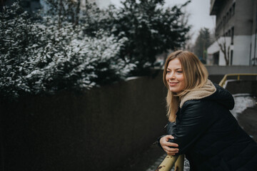 Poster - Closeup shot of a blonde happy female in a down jacket enjoying the view