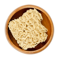 Dried instant noodles in a wooden bowl. Instant ramen are noodles sold in precooked and dried block form,  to be soaked in boiling water, but can be also consumed dry. Isolated over white, food photo.