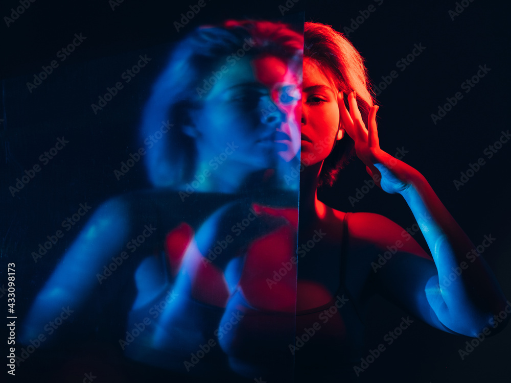 Mind control. Telepathy influence. Mental manipulation. Toxic relationship. Blur double exposure holographic silhouette of confident woman hypnotizing in pink blue neon light on dark. - obrazy, fototapety, plakaty 