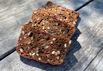 Sliced pieces of bread with seeds on a wooden background.