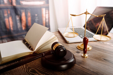 Justice and law concept.Male judge in a courtroom with the gavel, working with, computer and docking keyboard, eyeglasses, on table in morning light