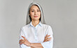 © insta_photos - Stylish confident adult 50 years old Asian female psychologist standing arms crossed looking at camera at gray background. Portrait of sophisticated grey hair woman advertising products and services.