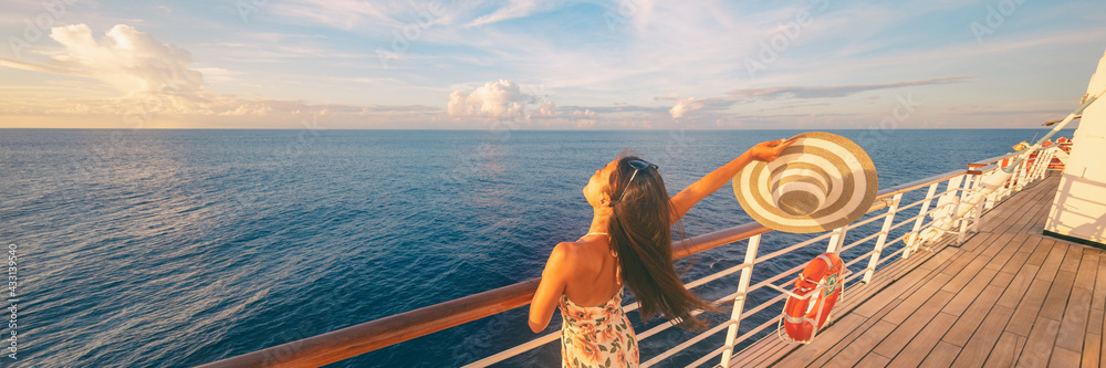 Happy cruise woman relaxing on deck feeling free watching sunset from ship on Caribbean travel vacation. Panoramic banner of sea and boat. - obrazy, fototapety, plakaty 