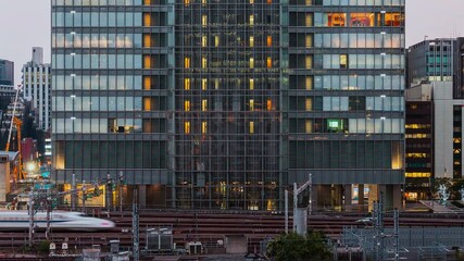 Wall Mural - Time lapse of elevator moving, people working, office window view on business center building facade, with train transportation railway. Corporate business or city commuter life concept