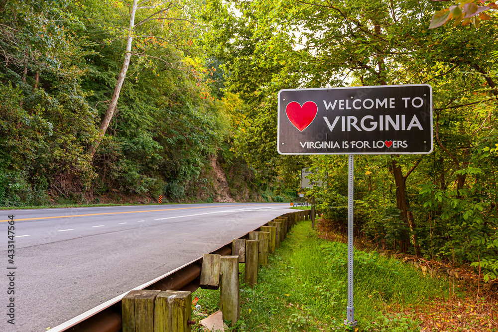 Welcome to Virginia sign located at the Maryland, Virginia state border at Purcellville, Virginia. The black sign has a red heart shape and 'Virginia is for lovers' slogan underneath.