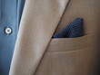 Close up of light grey jacket suit with extra wide collar shirt and lapel pin