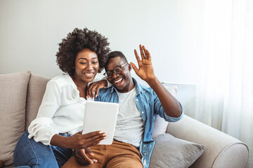 Shot of a happy young couple using their digital tablet to make a video call while relaxing together at home. Technology allows you to easily connect with your loved ones