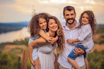 Wall Mural - Portrait of the smiling family standing in the vineyard. Time with family.