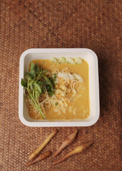 Wall Mural - Thai rice noodles in fish curry sauce with crab meat served with yard long bean on wooden plate.