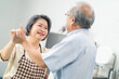 © Kawee - Asian senior couple dancing in the kitchen, Enjoy retirement life.