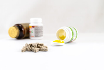 Jars with vitamins and vitamin pills on a light background