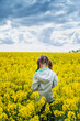 © Jess_Ivanova - Close up rear view of a beautiful girl in a rapeseed field. A child in a blooming field with yellow flowers.