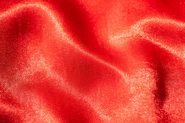 Abstract red silk fabric texture background. Cloth soft wave. Creases of satin