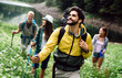 © NDABCREATIVITY - Adventure, travel, tourism, hike and people concept. Group of happy friends with backpack outdoors