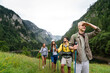 © NDABCREATIVITY - Adventure, travel, tourism, hike and people concept. Group of happy friends with backpack outdoors