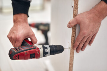 Wall Mural - Handyman worker assembling furniture and fixing it.