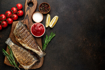 Wall Mural - grilled sea bass with spices on a stone background