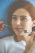 © rogerphoto - Smiling brunette woman being examined by dentist at dental clinic. Hands of a doctor holding dental instruments near patient's mouth. Healthy teeth and medicine concept
