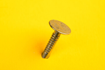 Metal nails close-up, lots of nails on a yellow background.