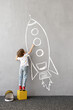 © Igor Yaruta - Happy kid draws a chalk rocket on the wall