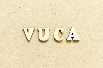 Sticker - Alphabet letter in word VUCA (abbreviation of Volatility, uncertainty, complexity and ambiguity) on wood background