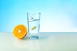 effervescent vitamin C tablet dissolves in water. a glass of water, effervescent tablet and citrus fruit on blue background. vitamin C concept