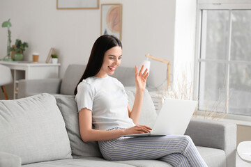 Poster - Beautiful young woman with laptop at home