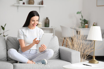 Poster - Beautiful young woman with tablet computer at home