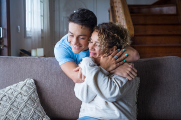 Wall Mural - Happy middle age mother spend time with teenager son, relatives people hugging at home, adult attentive millennial grateful child wrapped in a plaid or warm sweater loving mommy caring