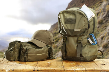 Wall Mural - Summer backpack on desk and landscape of mountains. 