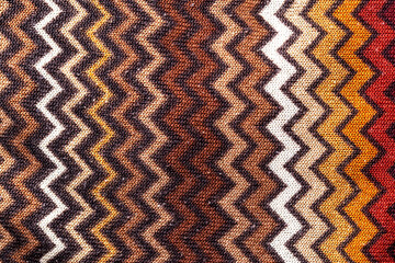 Herringbone material brown with orange, zigzags in mind of the pattern on clothes, background. Macro