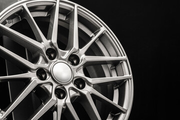 sporty lightweight alloy wheel, spokes and rim close-up on a black background