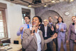 © Mediteraneo - Business people having a karaoke party at the office, singing, dancing and having fun while taking a break from a bussy work day