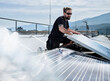 © Christian Vorhofer/Westend61 - Male electrician installing solar panels on building terrace during sunny day