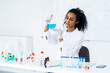 © Giorgio Fochesato/Westend61 - Young female chemist examining liquid in flask in laboratory