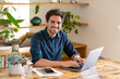 © steve brookland/Westend61 - Happy male freelancer working from home through laptop