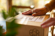 © Martin Barraud/Caia Image - Close up business owner placing shipping label on package