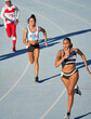 © Trevor Adeline/Caia Image - Female track and field athletes running on track in competition