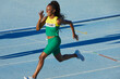 © Trevor Adeline/Caia Image - Smiling female track and field athlete running on sunny track