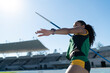 © Trevor Adeline/Caia Image - Focused female track and field athlete throwing javelin in stadium