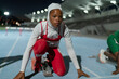 © Trevor Adeline/Caia Image - Focused female track and field athlete in hijab at starting block