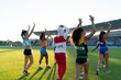 © Trevor Adeline/Caia Image - Track and field athletes waving to audience in stadium infield