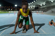 © Trevor Adeline/Caia Image - Portrait determined female track and field runner at starting block